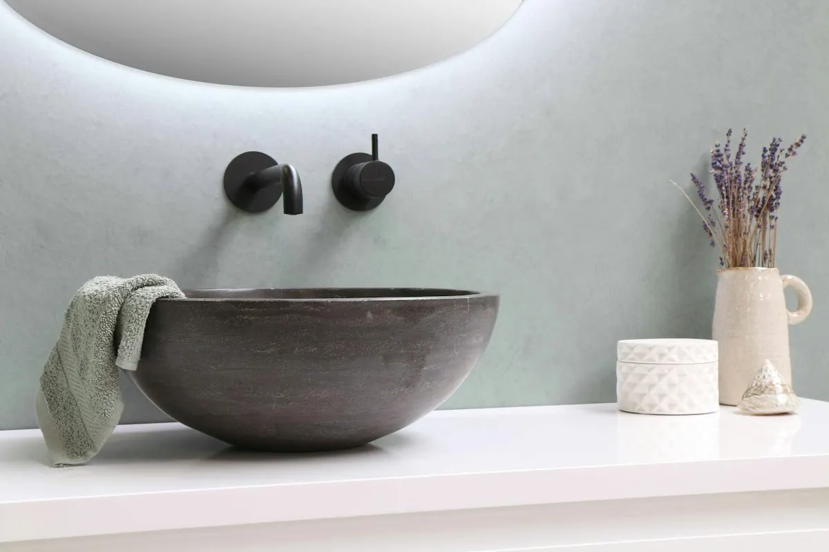 Close view of a grey vessel basin and wall-mounted taps