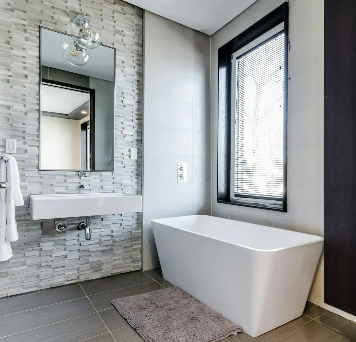 Freestanding bath beside a large bathroom window
