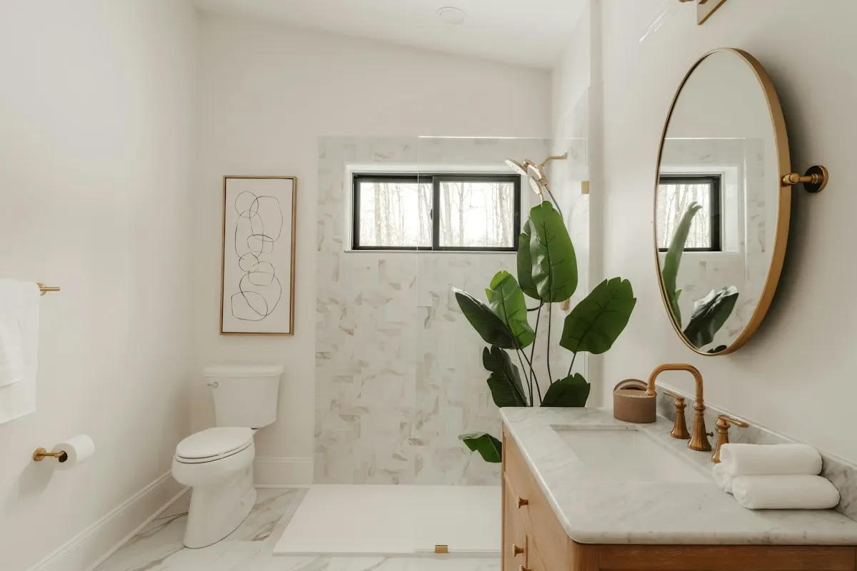 Samples of porcelain tile, solid-surface panel, quartz vanity top and a linear drain grate arranged on a workbench