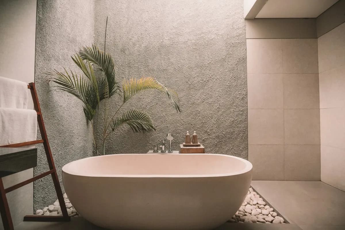 Freestanding bath beside textured tiled walls